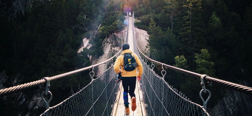 турист бежит по мосту через каньон